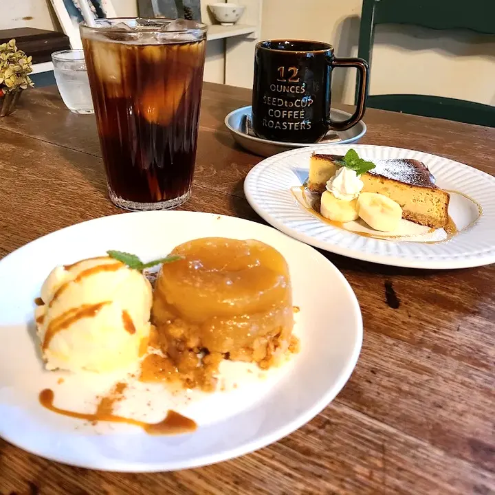 アイスを添えたケーキの皿と、奥にマグカップとグラス