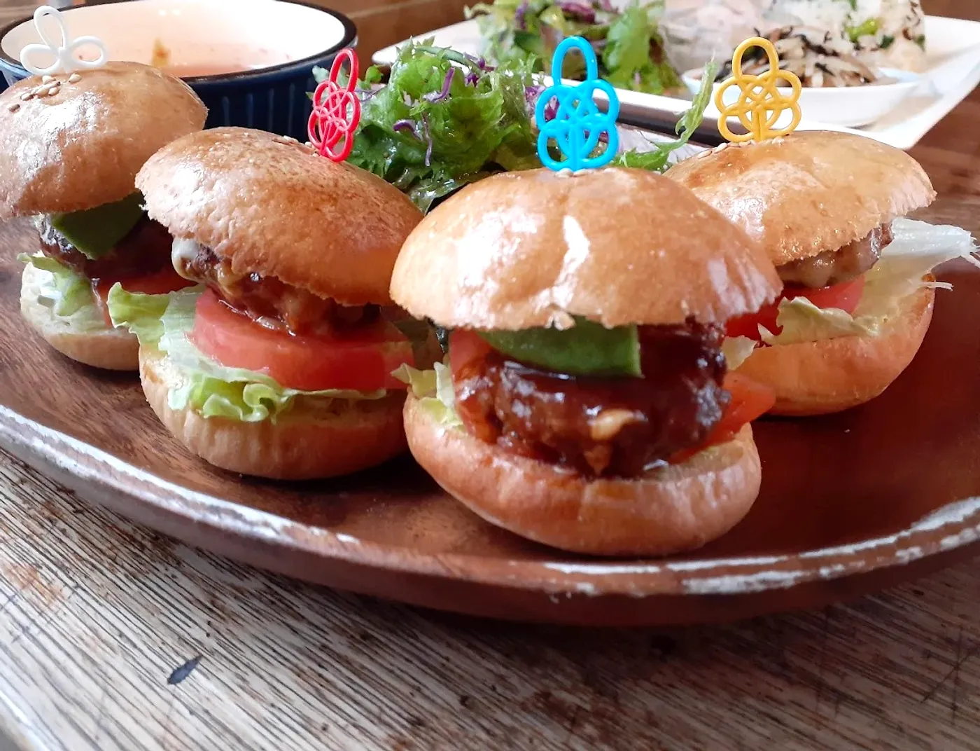 カラフルなピックがささったミニバーガー4つのプレート
